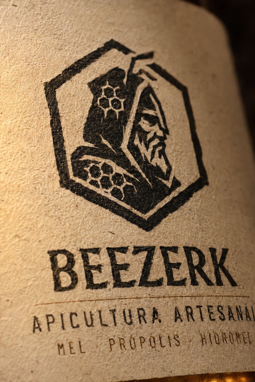 Detalhe do rótulo Beezerk em papel kraft, com o emblema entalhado e o nome em letras talhadas